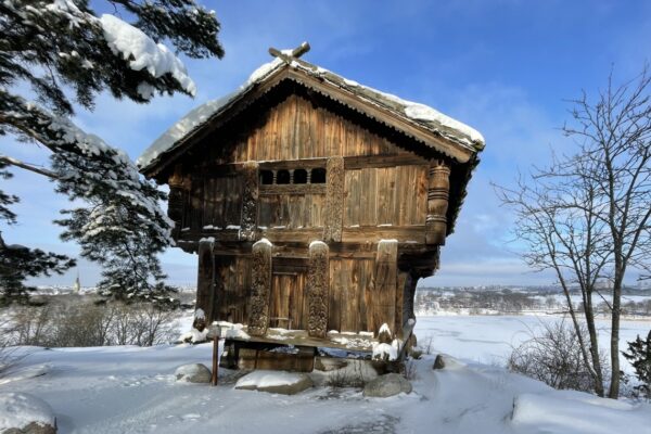 Liten träbyggnad på toppen av en snötäckt kulle